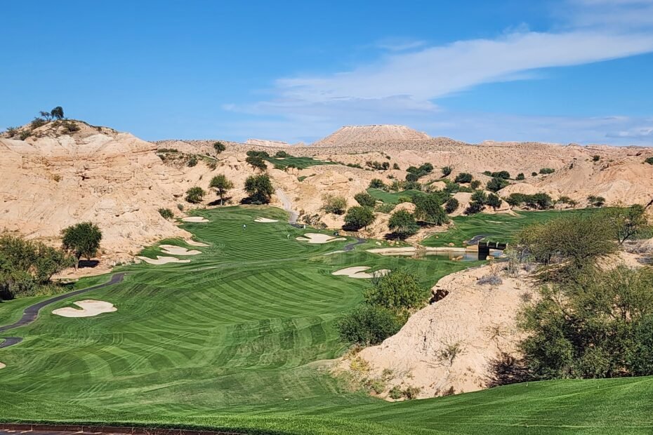 Fairway with mountain range and golf carts and a green