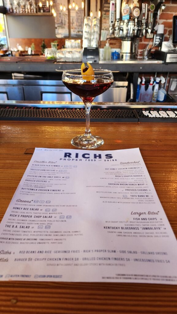 menu with a black Manhattan cocktail