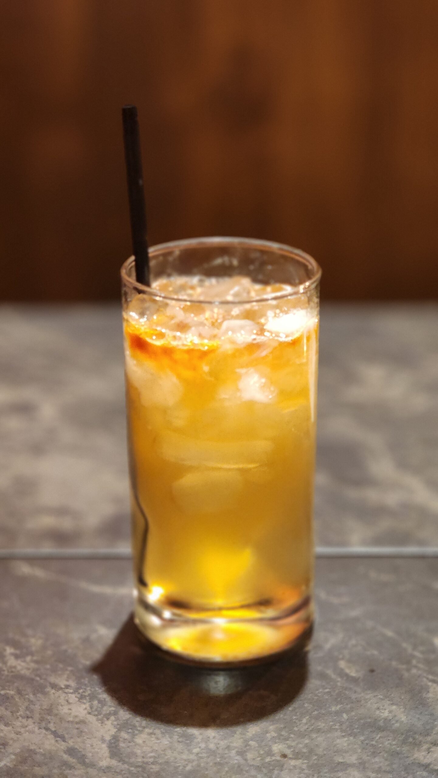 highball glass with ice a straw and a skeleton key cocktail